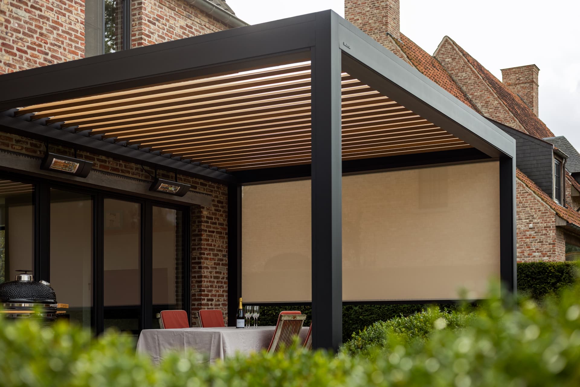 Brustor pergola with rotating louvres, integrated LED lighting, ZIP screens and mounted patio heaters creating a sheltered outdoor dining area