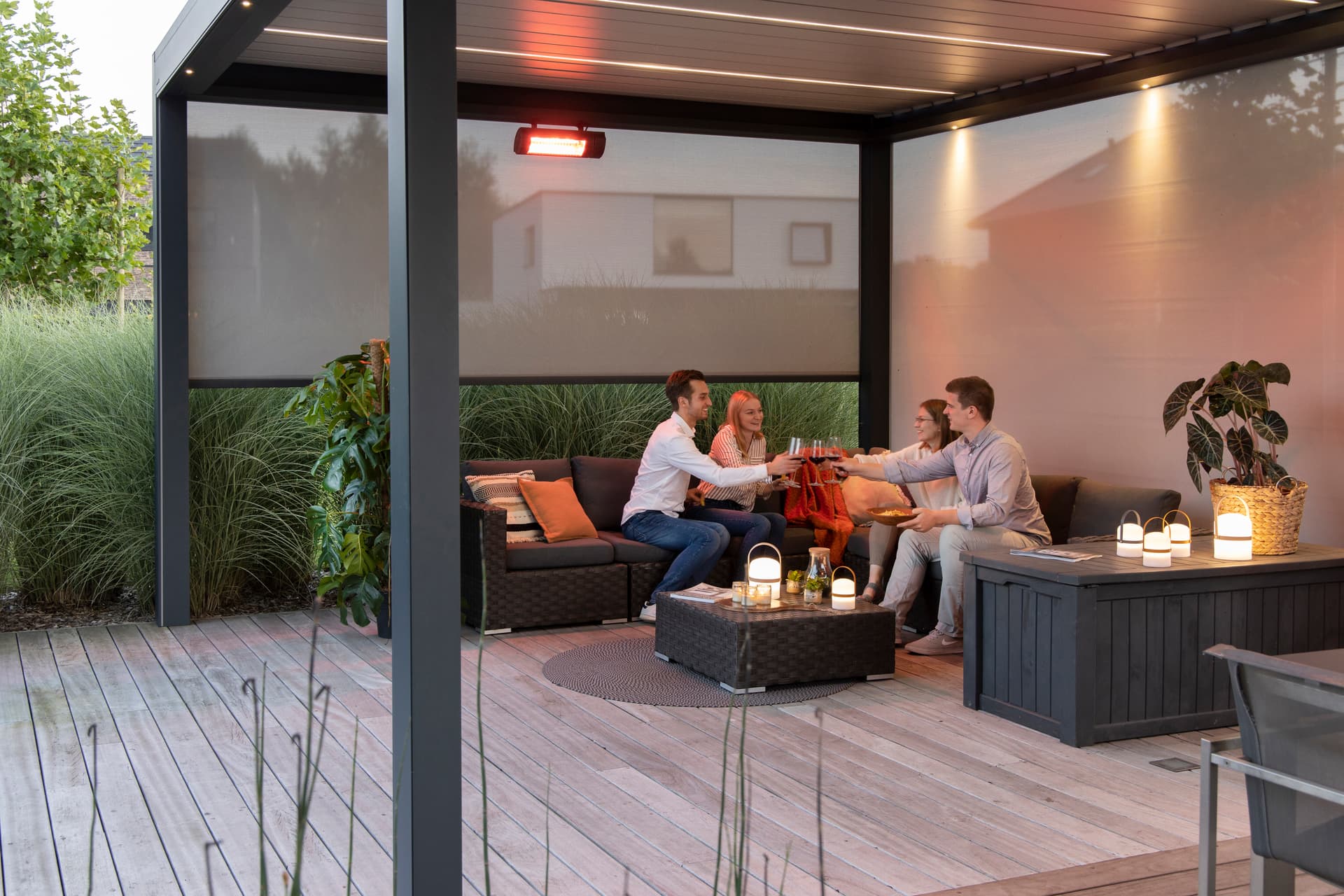 Brustor pergola equipped with ZIP screens, integrated LED lighting and a mounted patio heater creating a sheltered lounge area on a wooden terrace